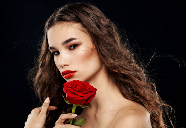 Женщина на темном фоне с цветком портрет брюнетки модели - Фото, изображение