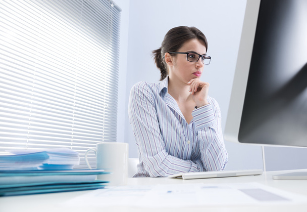 Pensive businesswoman at desk - Фото, изображение