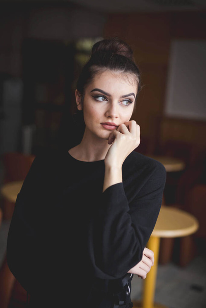 A shallow focus of a young brunette Caucasian female with simple makeup posing indoors - Fotoğraf, Görsel