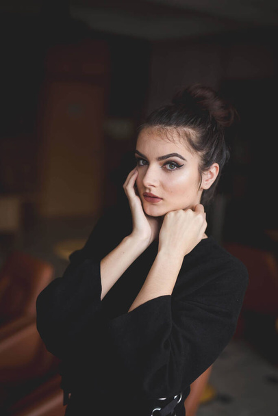 A shallow focus of a young brunette Caucasian female with simple makeup posing indoors - Foto, afbeelding