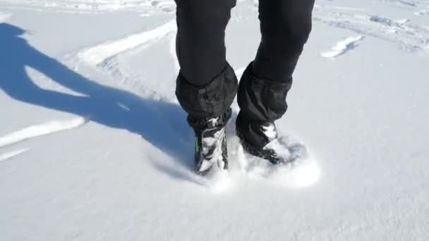 深い雪とスケートの動きのビューに乗ってホッケースケートを停止します。凍ったダムの自由な地形でのアイススケート。スローモーション. - 映像、動画