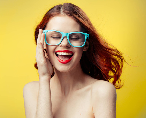 Çıplak omuzlu kadın kırmızı dudaklı mavi gözlüklü. - Fotoğraf, Görsel