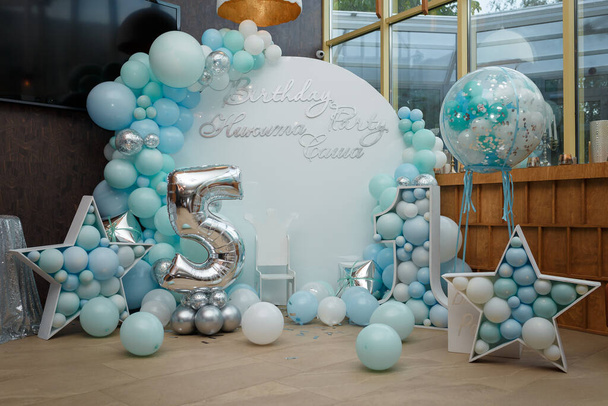Arch of blue balloons for boy happy birthday party. Number 5 and 1 for two brothers. Festive decorative elements, photo zone with star. Inscription Nikita, Sasha. - Photo, Image