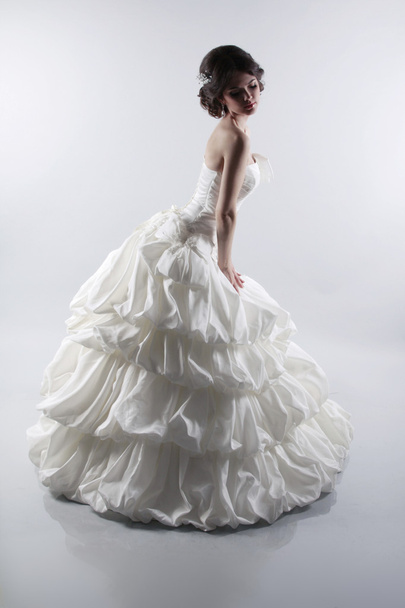 Glamorous bride woman in magnificent wedding dress isolated on g - 写真・画像