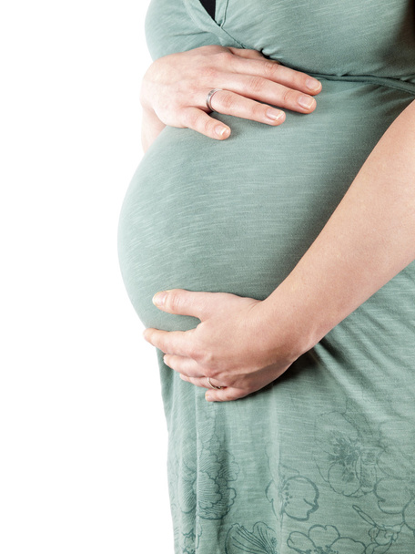 36 viikkoa raskaana oleva nuori nainen pitelee vatsaansa
 - Valokuva, kuva