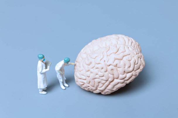 Miniatűr orvos ellenőrzése és elemzése alzheimer-kór és demencia az agy, a tudomány és az orvostudomány koncepció - Fotó, kép