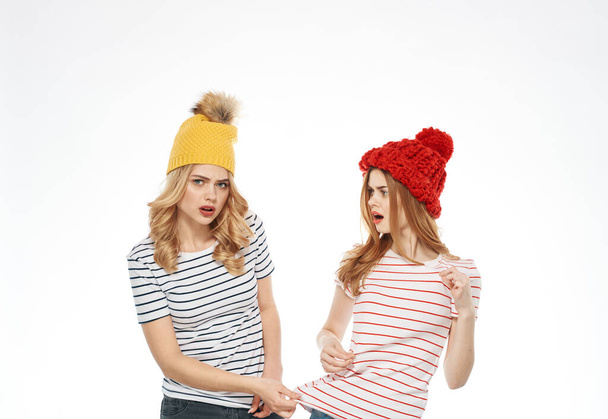 Wesołe dziewczyny paski t-shirty wielobarwne czapki emocje radość przycięte widok studio - Zdjęcie, obraz