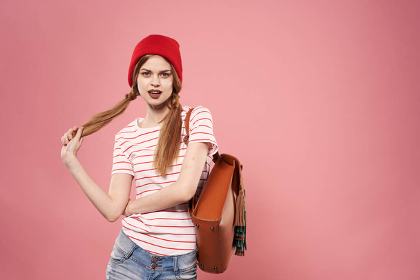 Fashionable glamorous woman in red hat backpack student hipster pink background - Photo, image