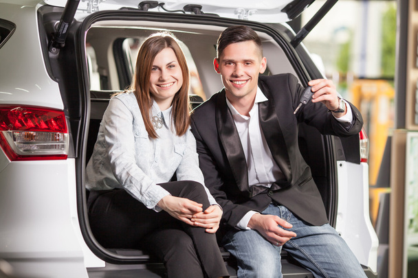 Счастливая молодая пара сидит на заднем сиденье автомобиля
 - Фото, изображение