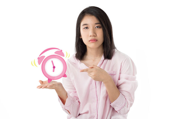 woman wear pink pajamas yawn and holding alarm clock feeling sleepy - Photo, Image