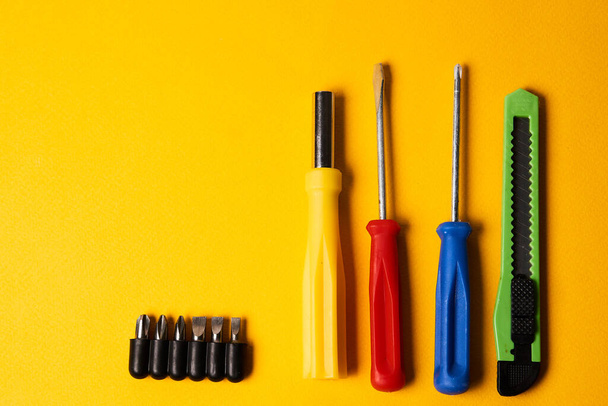 Építőipari szerszámok csavarhúzó kés fúvókák javítás sárga háttér - Fotó, kép