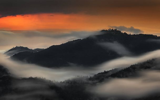 Skofja Loka, Eslovenia - Larga exposición panorámica de las montañas de la región de Kranj tomada de Jamnik con niebla matutina de verano y cielo dorado al amanecer - Foto, imagen