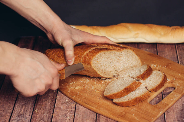 cutting a fresh loaf on a cutting board crispy bread kitchen meal - Photo, Image