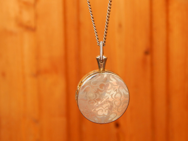 Belo colar de prata em forma de círculo sobre fundo de madeira
 - Foto, Imagem