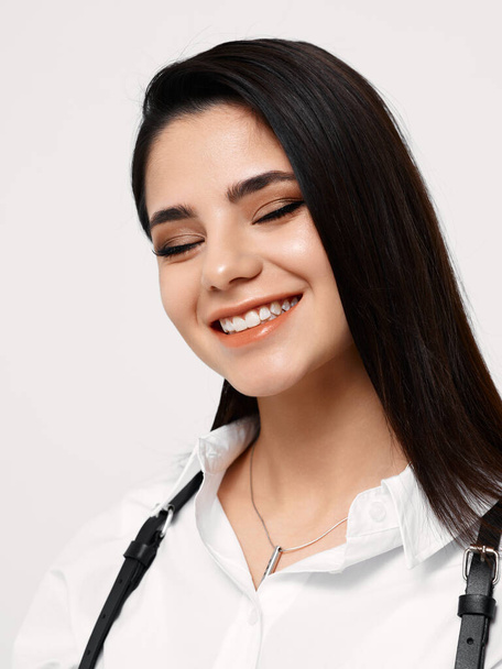 happy brunette in white shirt with black suspenders and makeup portrait close-up - Fotoğraf, Görsel
