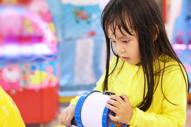 Azjatyckie dzieci słodkie lub dziecko dziewczyna niegrzeczny i zabawy z gry zabawki i gry aż pocenie się do aktywności i nauki w przedszkolu lub placu zabaw z nosić żółtą koszulę - Zdjęcie, obraz