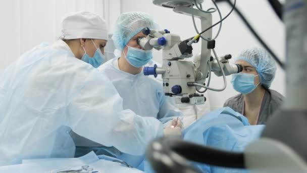 équipe de chirurgie faisant chirurgie du strabisme en utilisant les technologies modernes, les derniers appareils, microscope dans la clinique moderne - Séquence, vidéo
