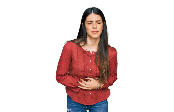 Mujer hispana joven usando ropa casual con la mano en el estómago porque la indigestión, la enfermedad dolorosa sensación de malestar. concepto ache.  - Foto, imagen