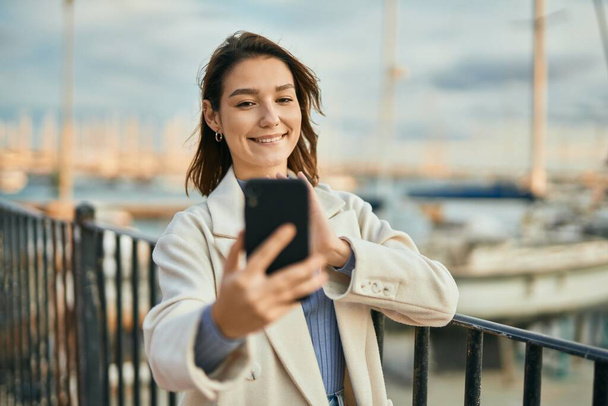 Young hispanic woman smiling happy doing video call using smartphone at the city. - Photo, Image