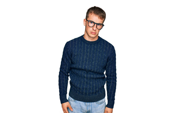 Young blond man wearing casual clothes and glasses skeptic and nervous, frowning upset because of problem. negative person.  - Photo, Image