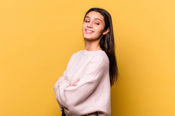 Young Indian woman isolated on yellow background smiling confident with crossed arms. - Photo, image
