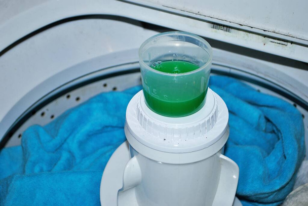 load of dirty towels in a washing machine with laundry detergent - Photo, Image