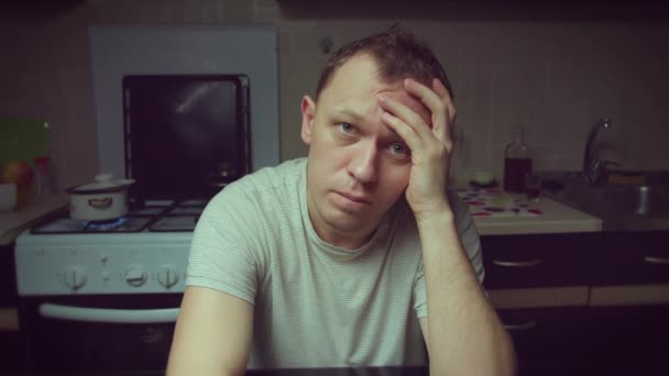 Portret van een jonge man in depressie thuis aan tafel, camerabeweging - Video