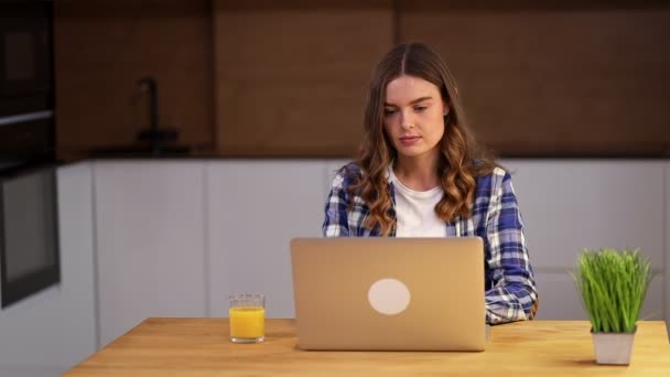 Cours à distance pour une jeune femme, elle ouvre un ordinateur, fait le concept de travail à distance à une table de la maison, sirotant du jus d'orange. - Séquence, vidéo