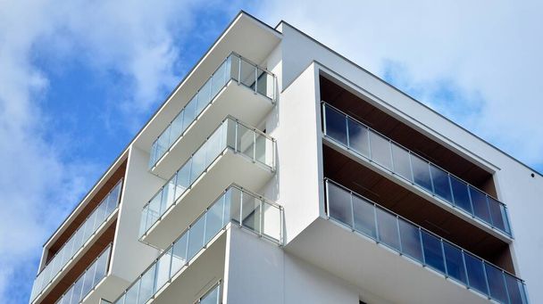 Architecture carrée futuriste de l'immeuble d'appartements. Immobilier avec fenêtres panoramiques et ciel bleu avec nuages. - Photo, image