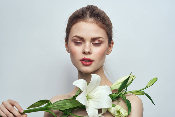 woman with white flowers on gray background portrait close-up makeup mode - Фото, изображение