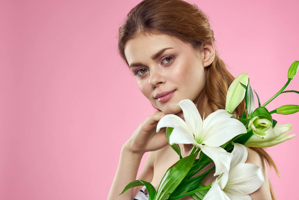 Portrait of woman with white flowers beautiful face pink background naked shoulders - Φωτογραφία, εικόνα