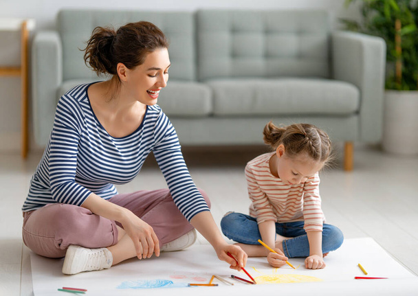 Happy family. Mother and daughter drawing together. Adult woman spending time with child girl.    - 写真・画像