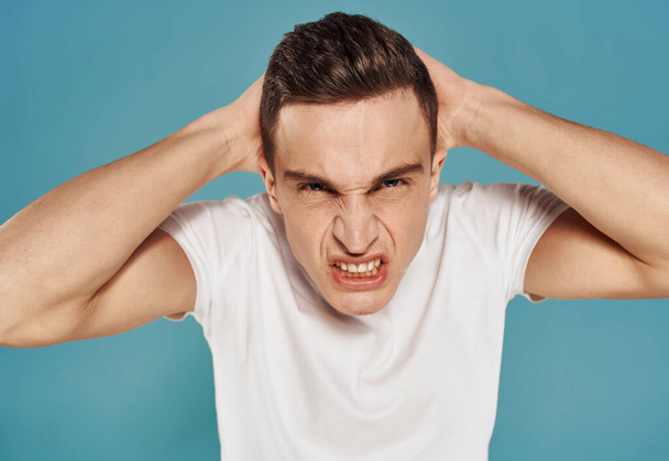 Angry man in white t-shirt gesture with hands displeasure blue background - Foto, Bild