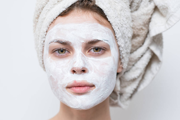 jolie femme avec serviette sur la tête masque crème sur le visage gros plan - Photo, image