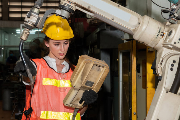 Smart factory job werknemer controle robotarm in productiewerkplaats - Foto, afbeelding