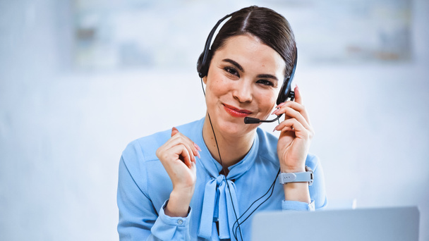 joyful call center operator smiling at camera while working in office - Photo, Image