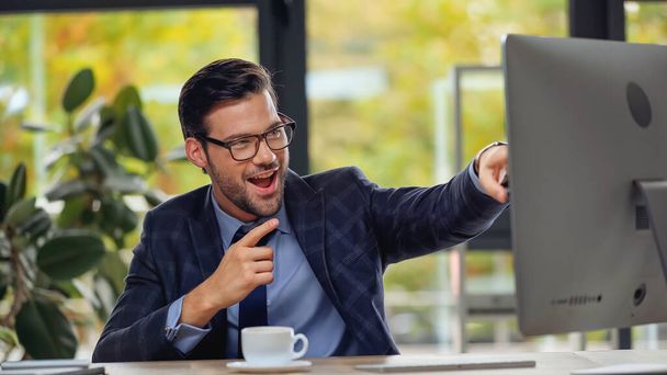 homem de negócios em óculos apontando com o dedo para monitor de computador  - Foto, Imagem