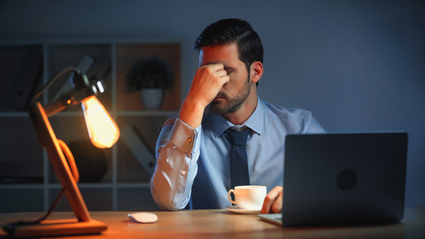 fáradt üzletember megérinti szemét, miközben késő estig dolgozik az irodában - Fotó, kép