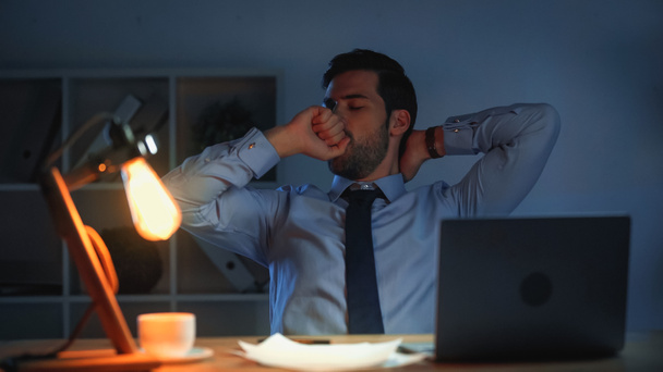 tired businessman yawning while working late in office - Photo, Image