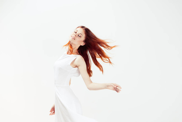 白いドレスの女性赤い髪の輝きの動き - 写真・画像