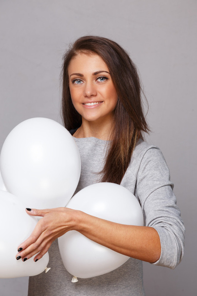Woman in gray shirt with white balloons - Photo, Image