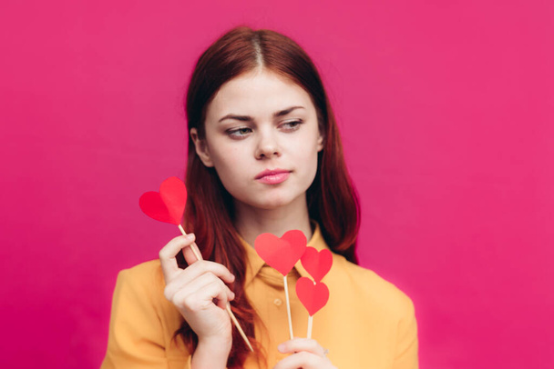 emotional woman with paper hearts on a stick on a pink background and Valentines Day - Foto, immagini