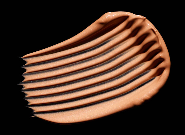 Штрих макияжа фундамент изолирован на черном фоне - Фото, изображение