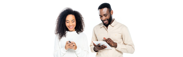šťastný africký americký pár pomocí gadgets izolované na bílém, banner - Fotografie, Obrázek