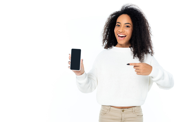 amazed african american woman pointing at cellphone with blank screen isolated on white - Photo, Image