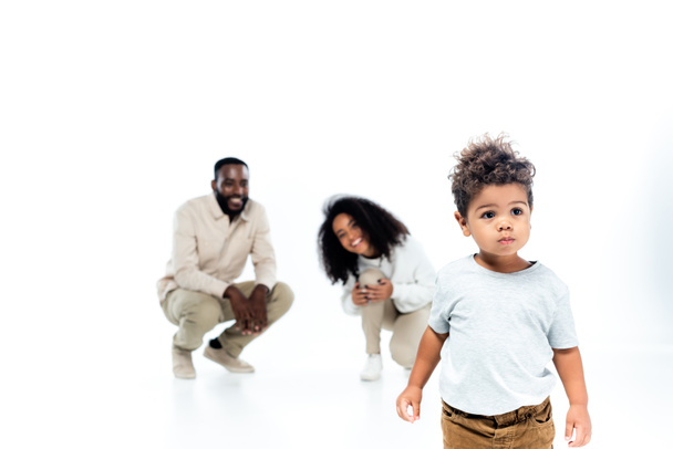 little african american boy standing near cheerful parents on blurred background on white - Photo, Image