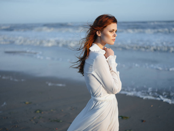 Charming woman in a sundress near the ocean on the shore of the beach model red hair - Zdjęcie, obraz