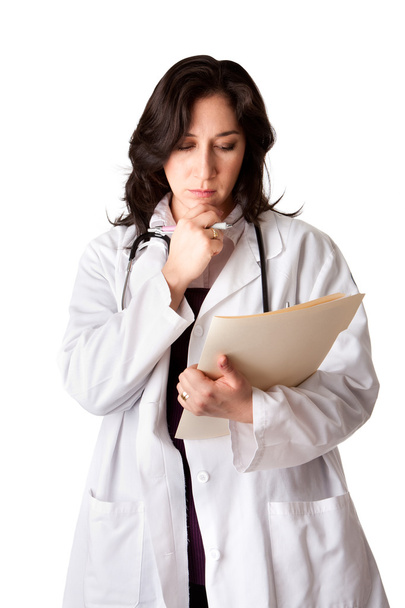 Female doctor in white coat looking at patient record chart and thinking about health, isolated. - Foto, immagini