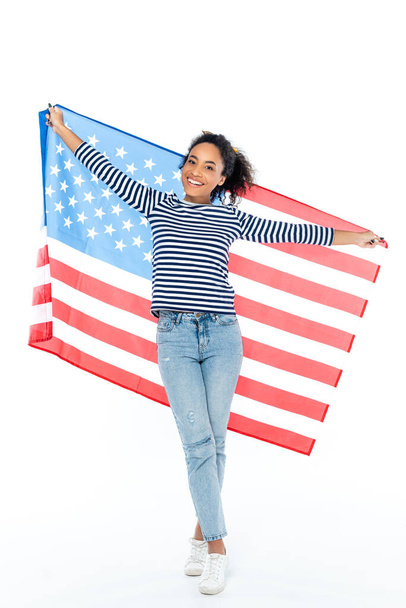 volle Länge Ansicht der glücklichen afrikanisch-amerikanischen Frau steht mit US-Flagge auf weiß - Foto, Bild
