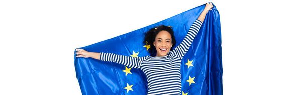 radostná afroamerická žena držící vlajku Evropské unie izolovanou na bílém praporu - Fotografie, Obrázek